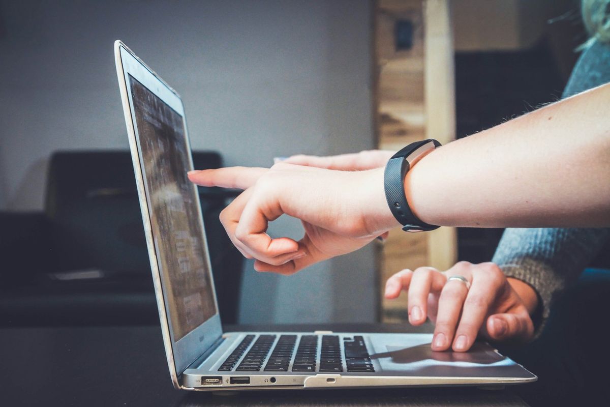 An instructor guiding a student at a laptop